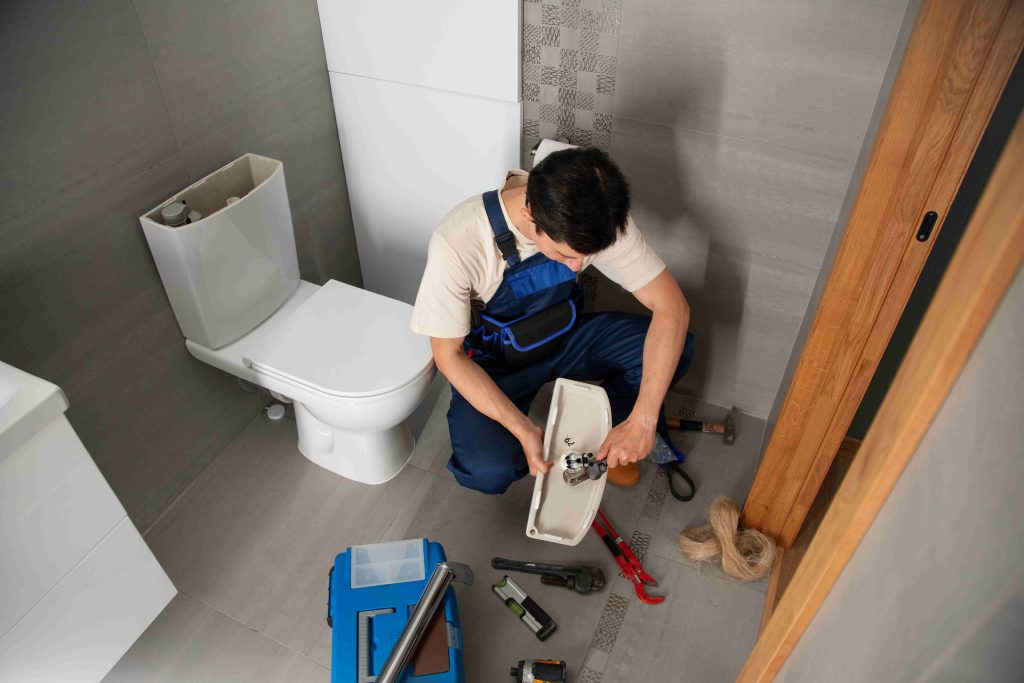 A superhero plunger vanquishes a clog monster in a Petaling Jaya toilet, symbolizing House Hero's toilet repair prowess.